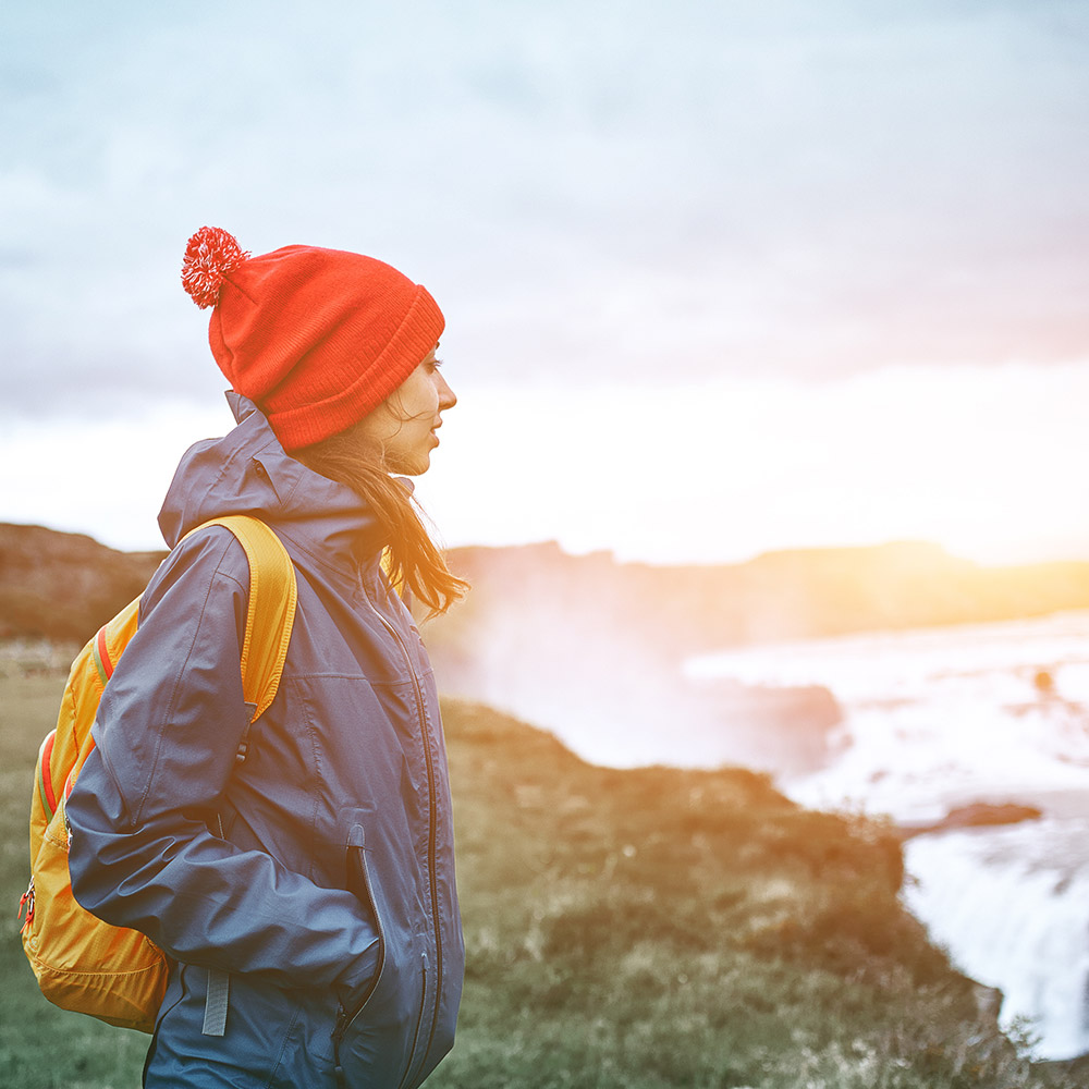 Woman hiking overlooking a waterfall