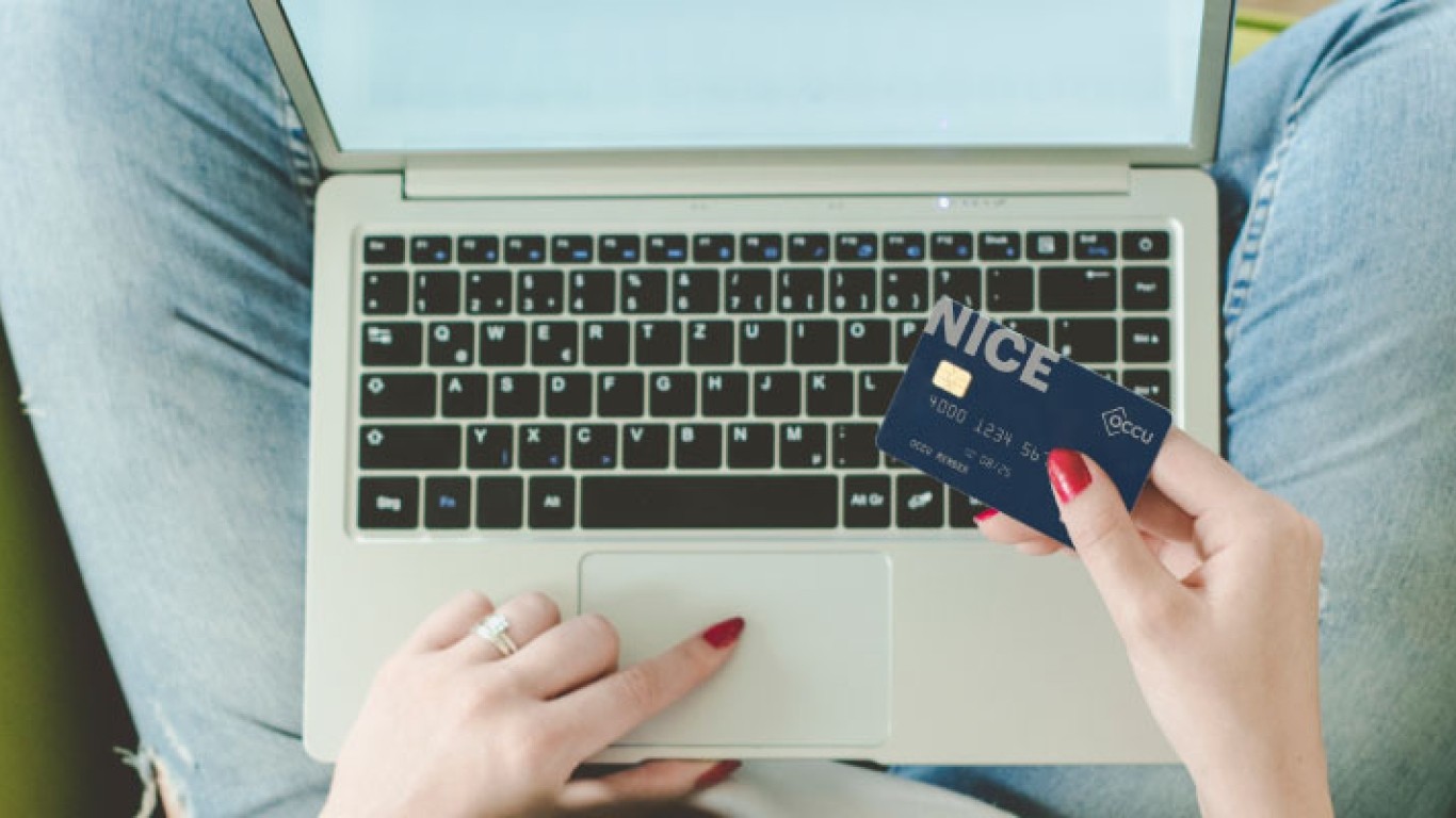 A woman on her laptop with a credit card in her hand
