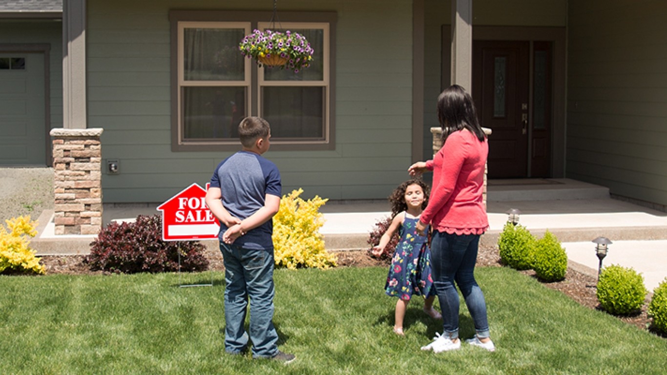 Family in front of a for sale house