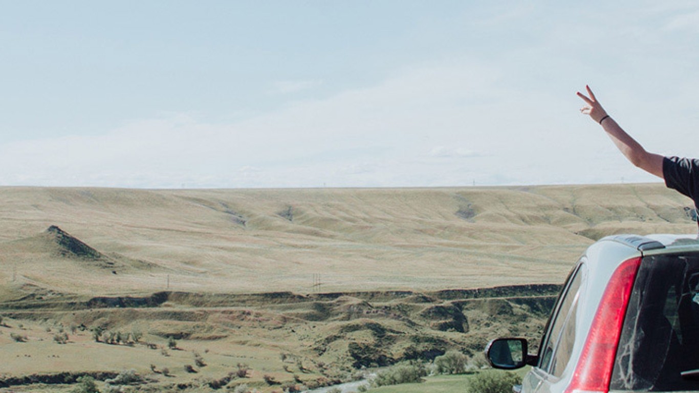 Woman with car overlooking desert vista