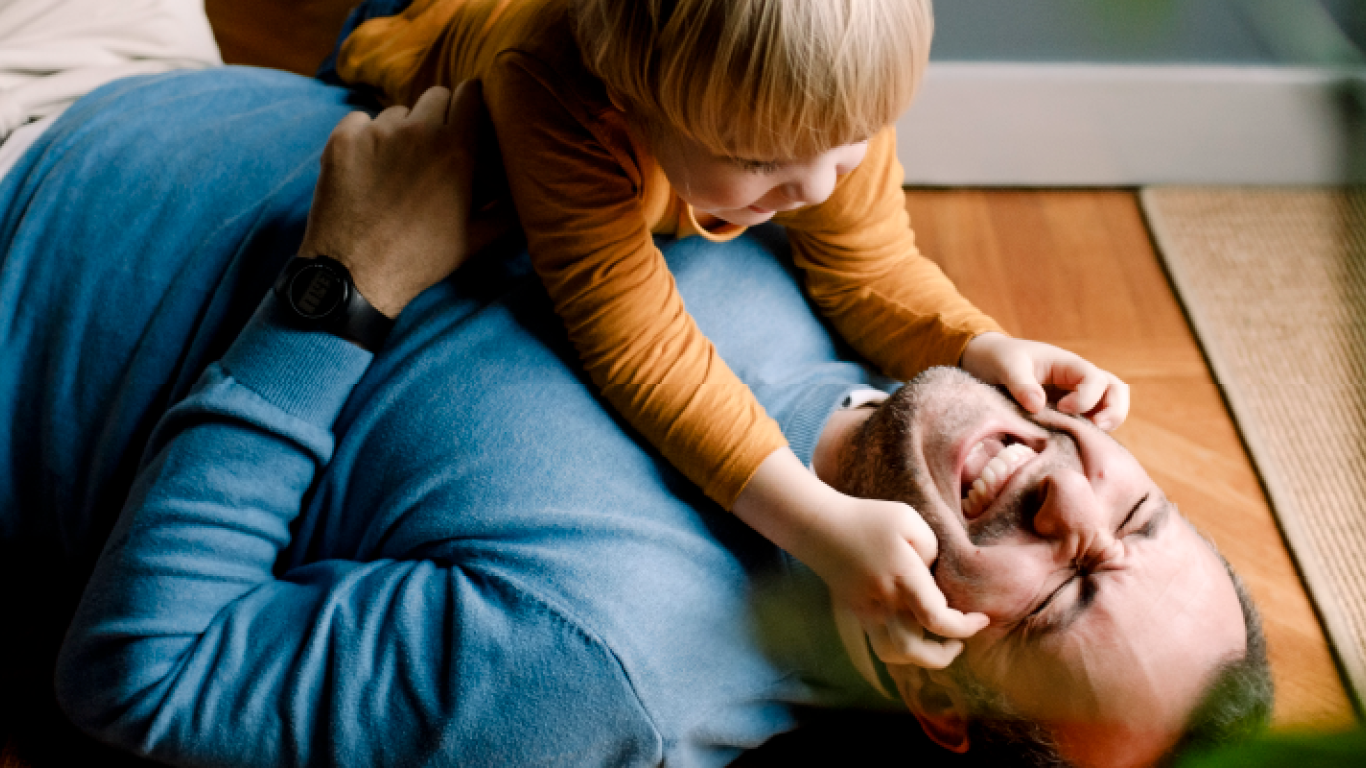 man and baby playing