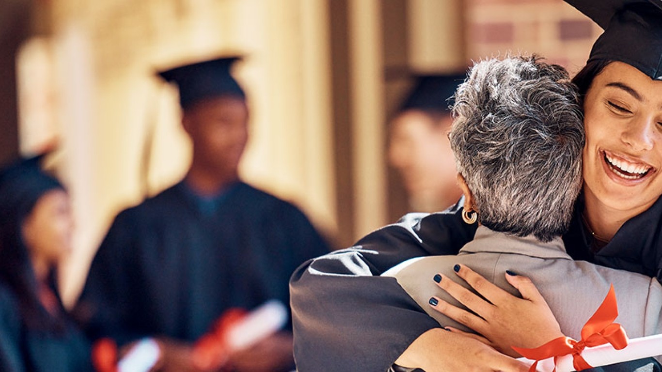 Female graduate student hugging woman