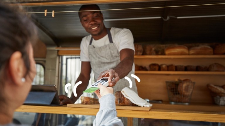 Man asks for payment in his shop. 