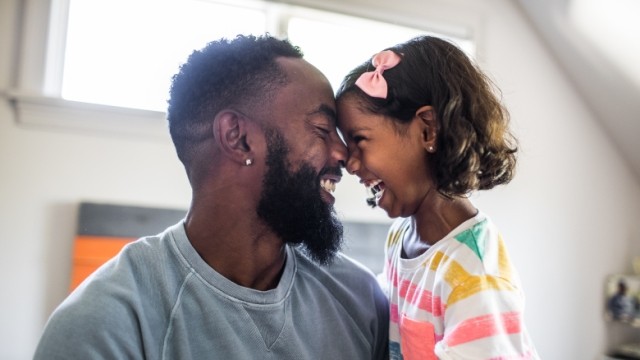 Father and daughter, grinning face to face.