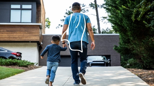 A Dad and his son, walking up a driveway. The Dad has a cape doodled on his back.