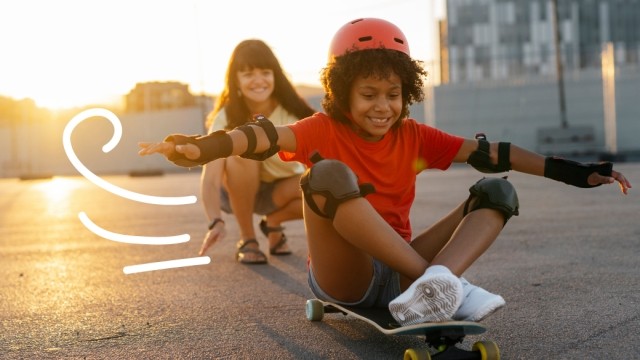 Child on a skateboard playing with their Mom.