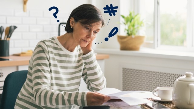 Woman looking at paperwork at her kitchen table