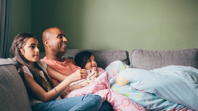 Dad watching movie with daughters