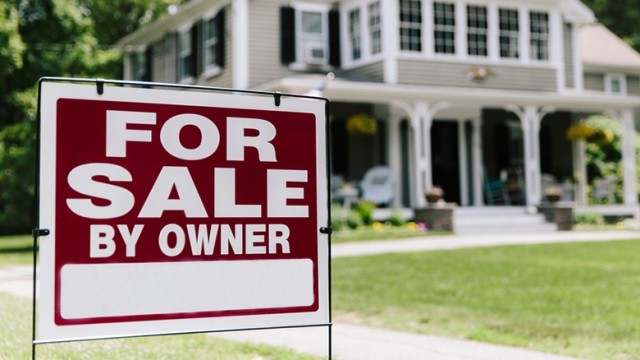 For sale by owner sign and white house