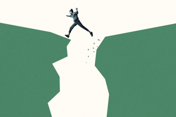 Girl stepping across large space between two large green cliffs.