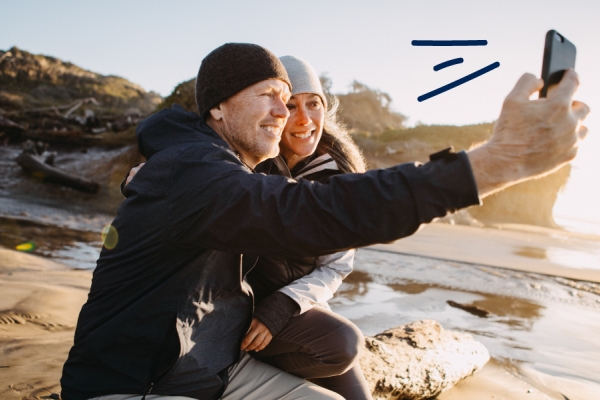 Couple takes a selfie by the ocean.