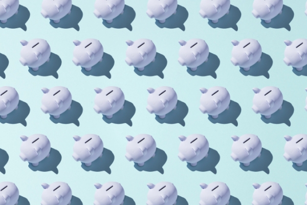 Porcelain white piggy banks in rows with shadows on light blue background.
