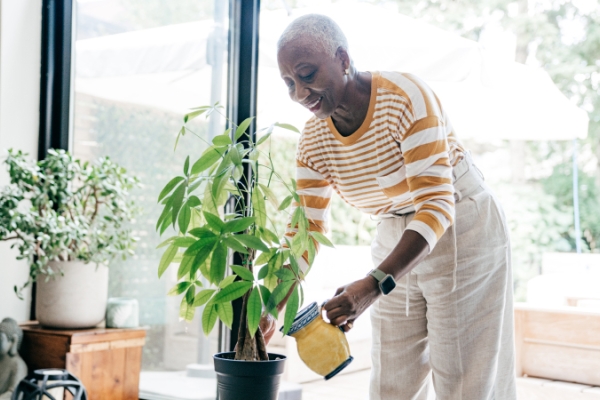 Woman smiling and watering money tree