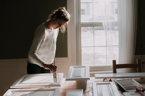 Woman painting cabinet doors