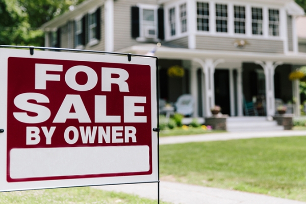For sale by owner sign and white house