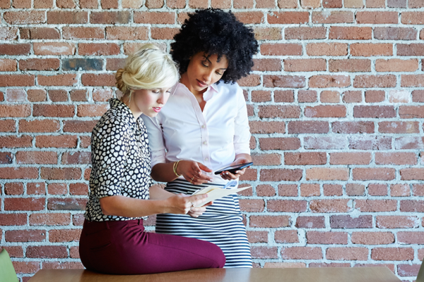 Two young women around a conference table