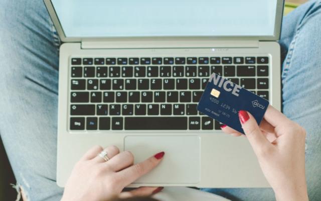 A woman on her laptop with a credit card in her hand