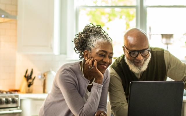 older couple looking at laptop and smiling