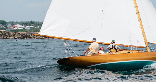 Three people sailing on a boat in the ocean