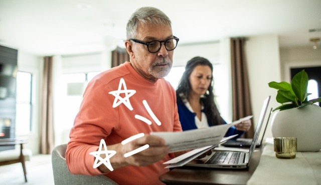 Man with glasses looks over his bills. 