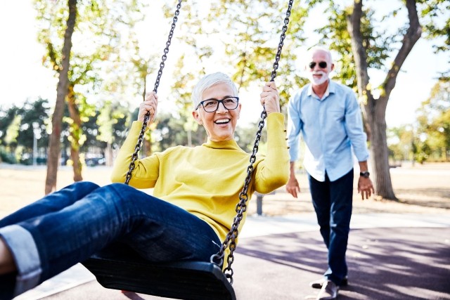 Mature couple on swings in a park