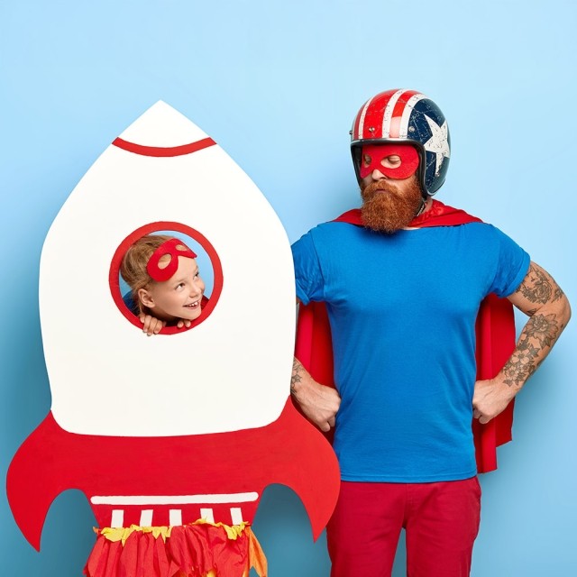 Dad and daughter playing as a rocket and superhero